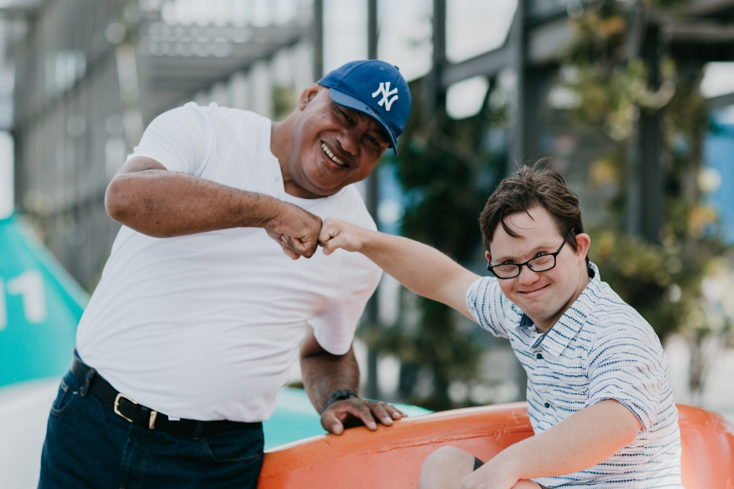 Two men smiling and fist pumping each other outside