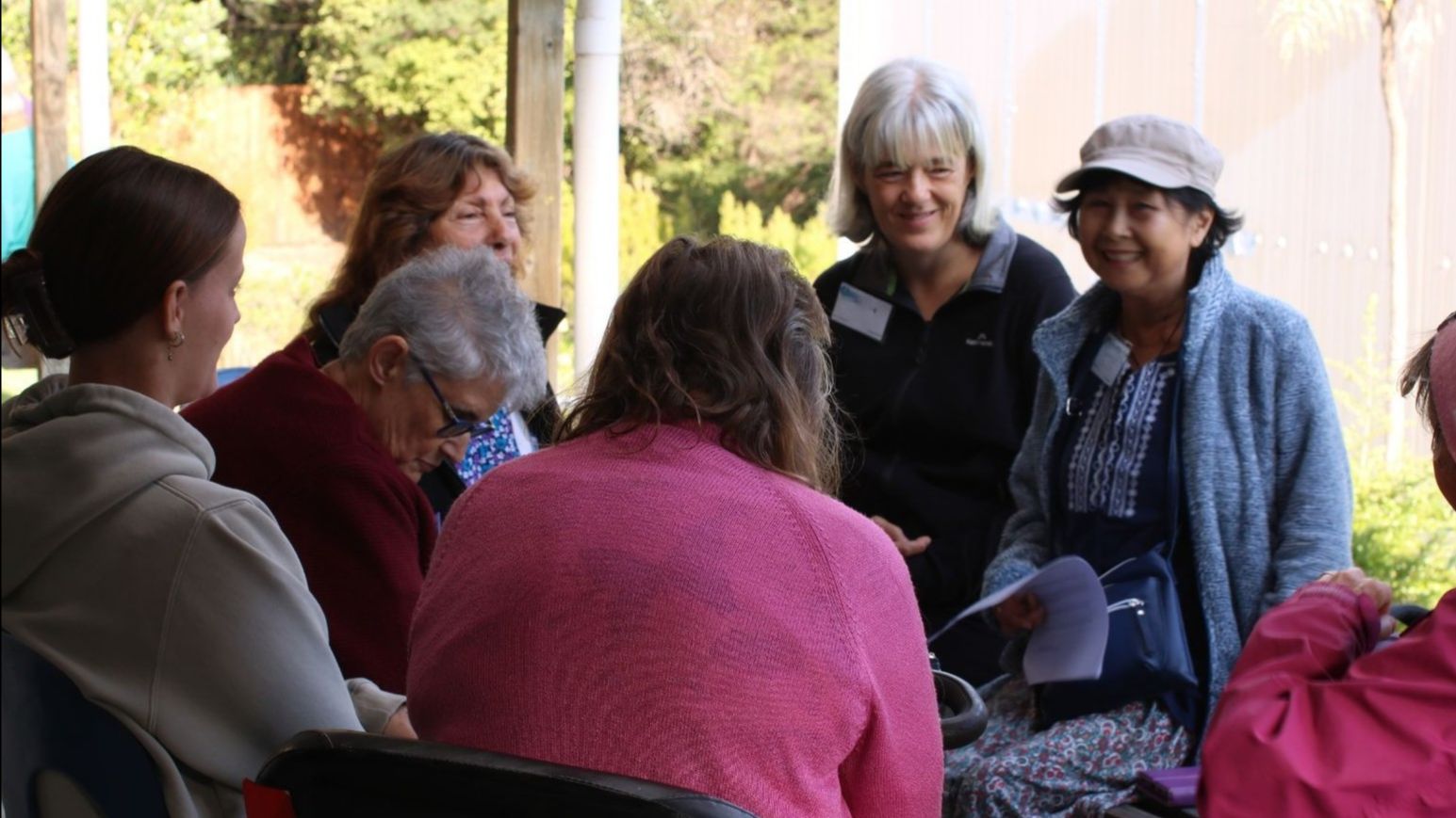 Group of people at an Auckland CFFD event chatting out on the porch on a sunny day