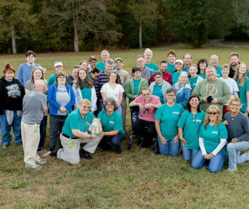 The Ability Ministry team gathered on a field for a large group photo outside