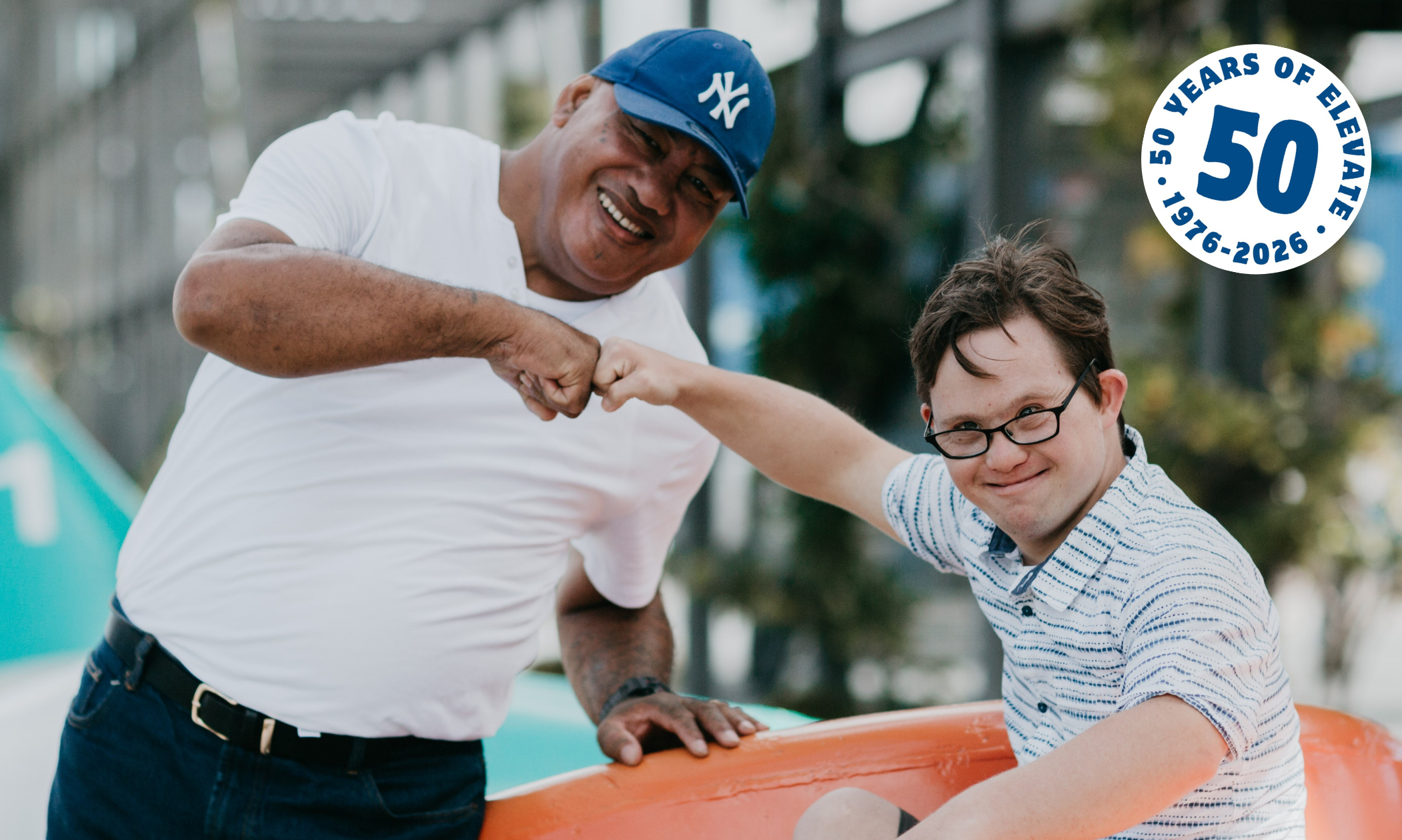 Two men smiling and fist pumping each other outside