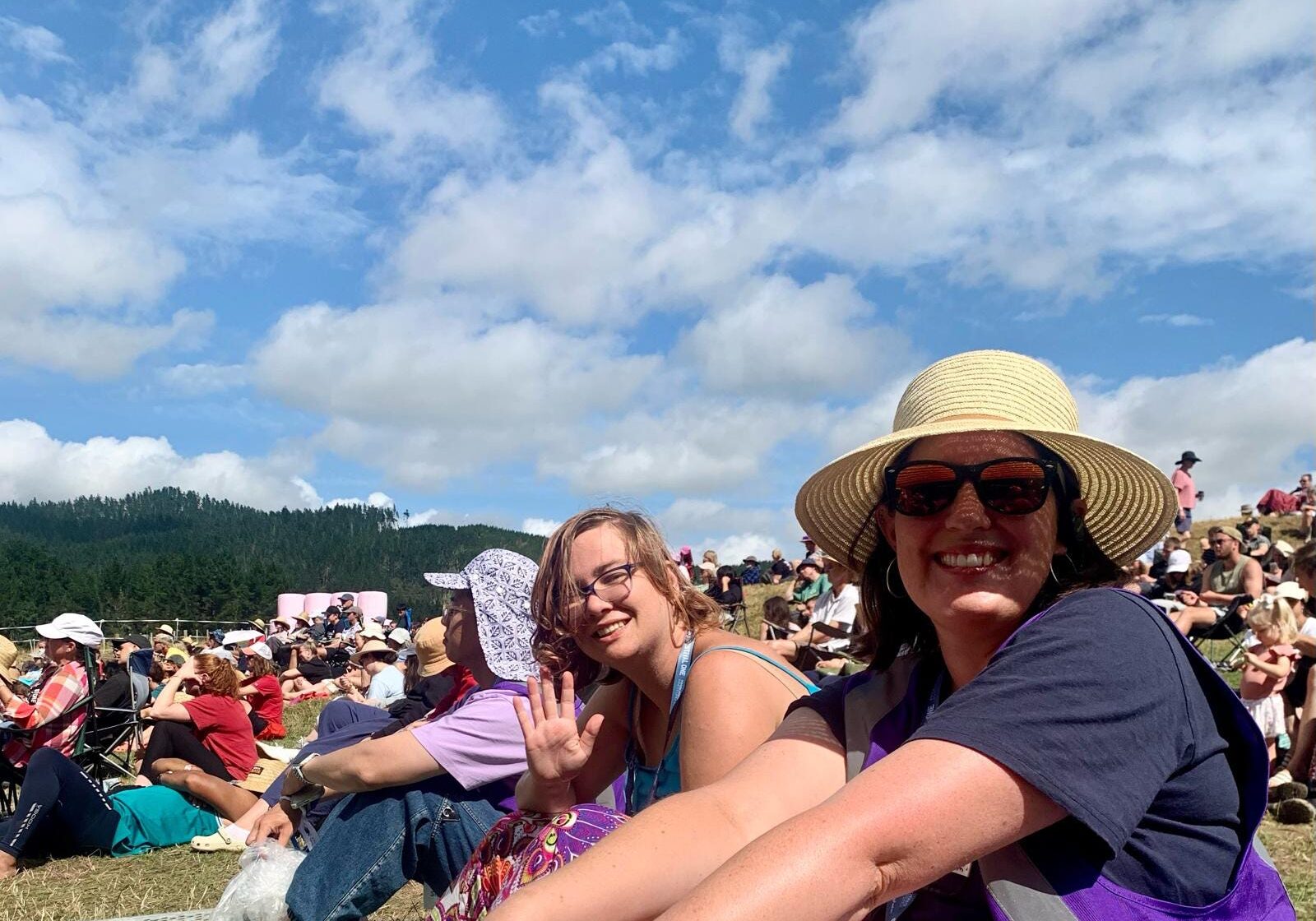 Two Soul Lounge volunteers are sitting in the sun at Festival One in 2023 listening to music