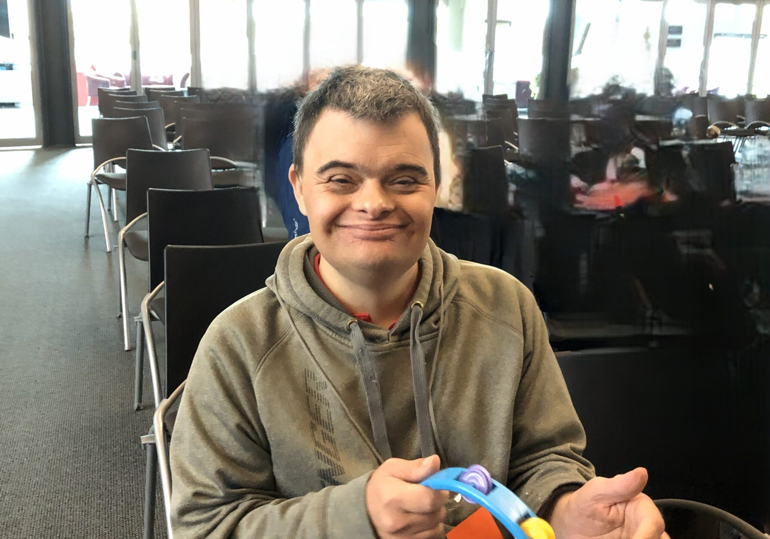 A man worshipping at Joy Ministries with a tamborine