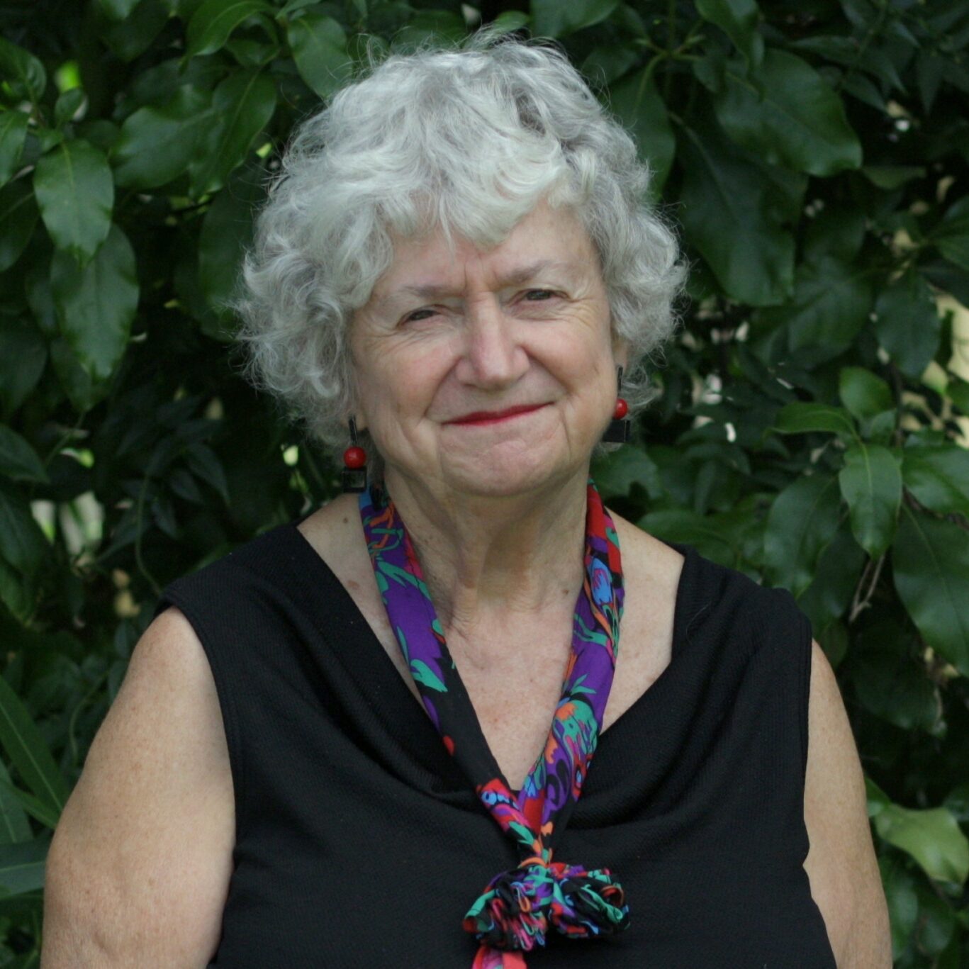 Di Willis sports short grey curly hair with a black singlet top and colourful necktie.