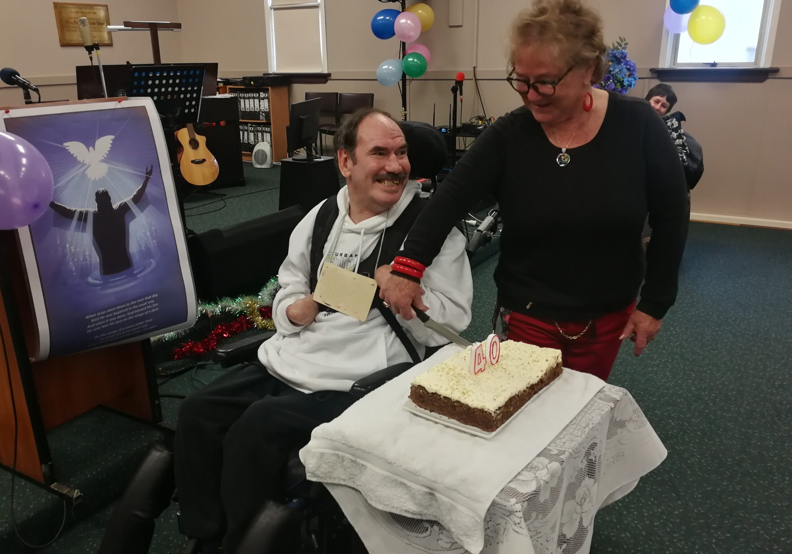 Two members of Dunedin CFFD cutting a cake to celebrate a member's birthday