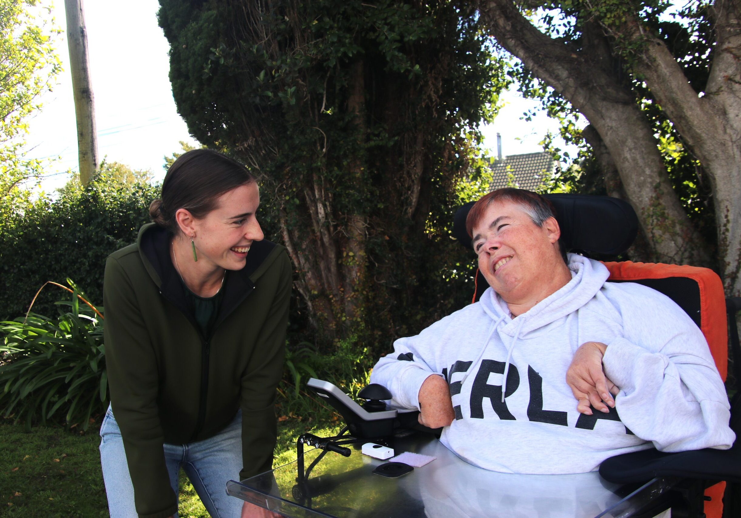 Elevate staff member is chatting with a drop-in centre attendee outside in the sun
