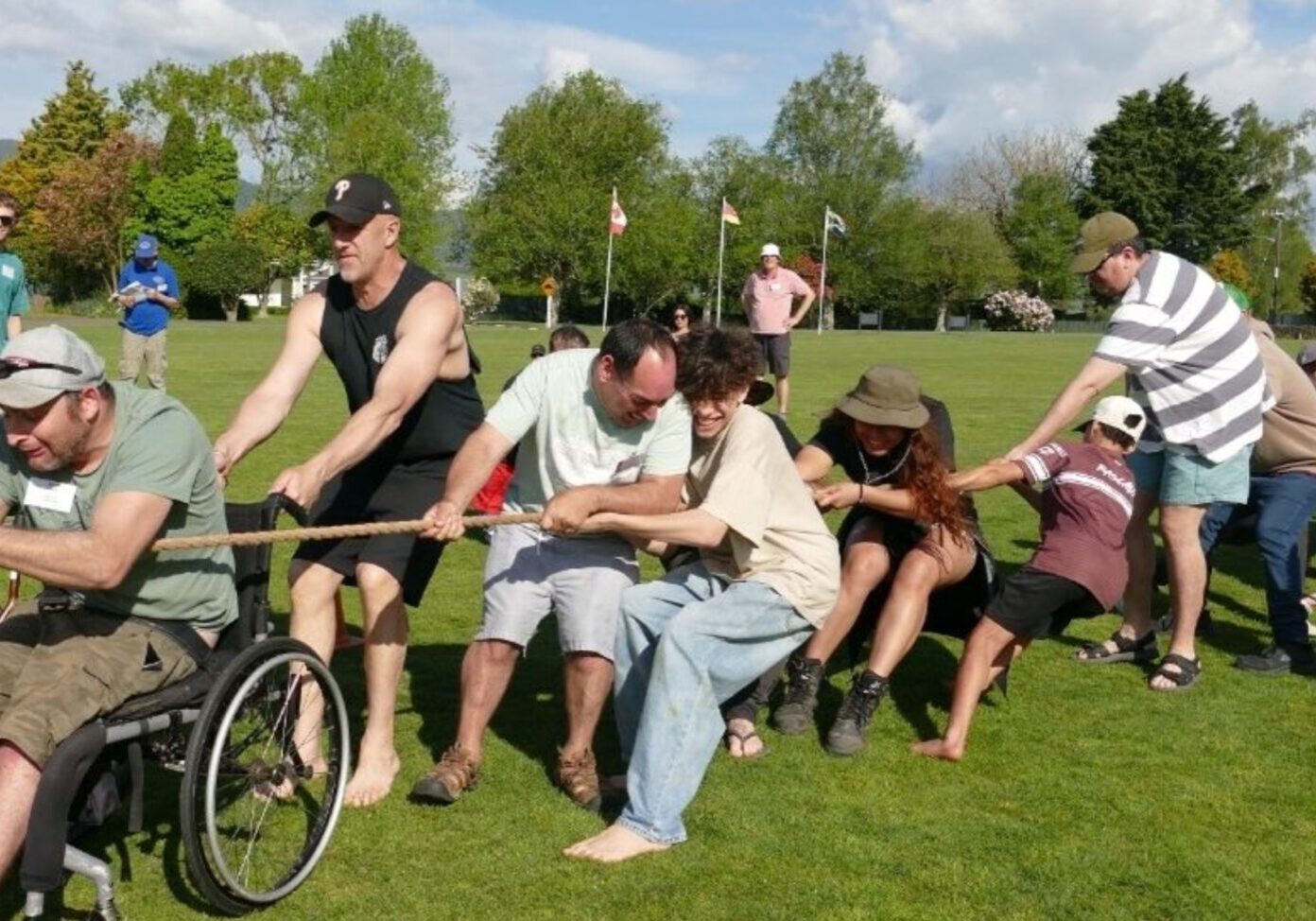 Large group playing tug of war on a field at a National Camp